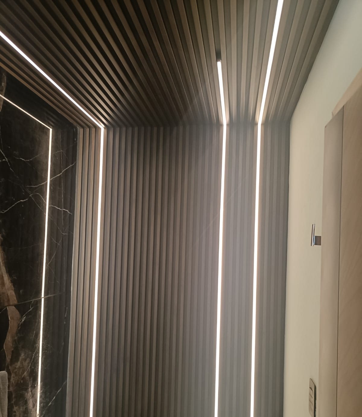 Lambrín con tiras LED en medio baño
