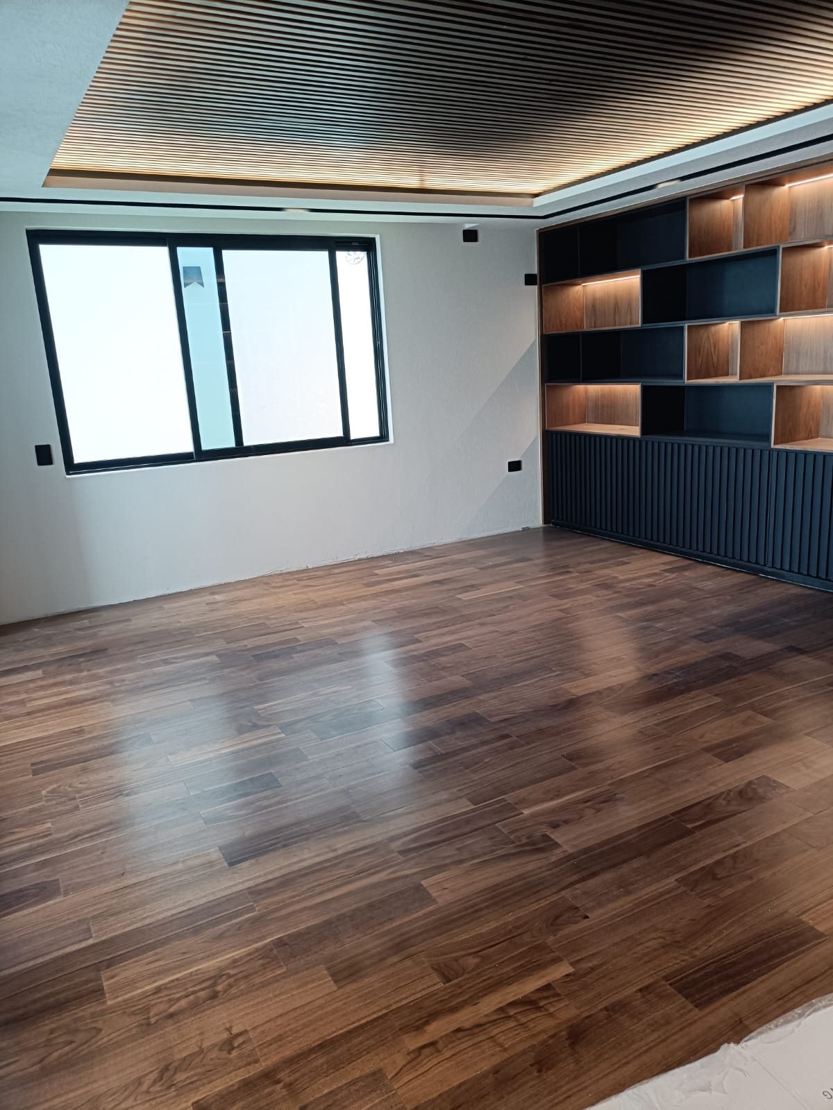 Piso de ingeniería en nogal en estudio con librero