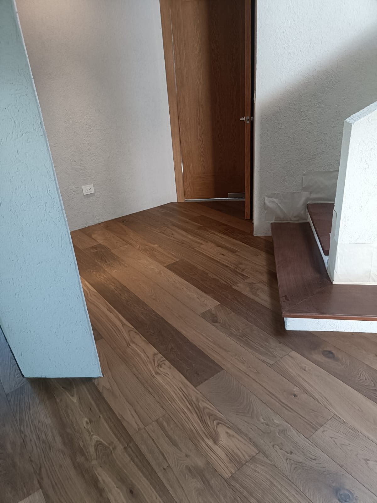 Piso de ingeniería en pasillo con escalón de madera