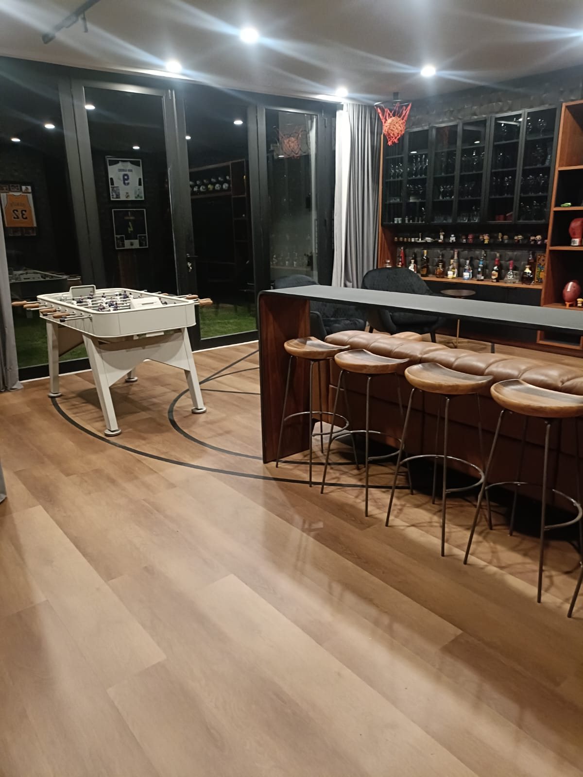 Piso vinílico SPC en salón de juegos con bar