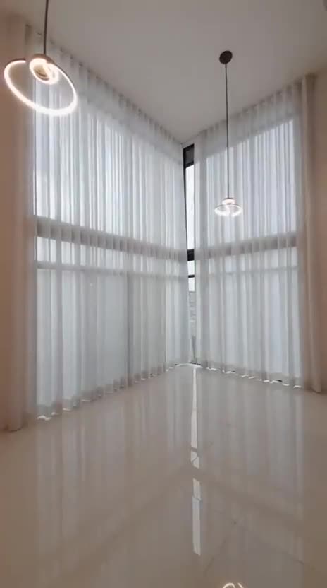 Cortinas translúcidas en ventanal de doble altura